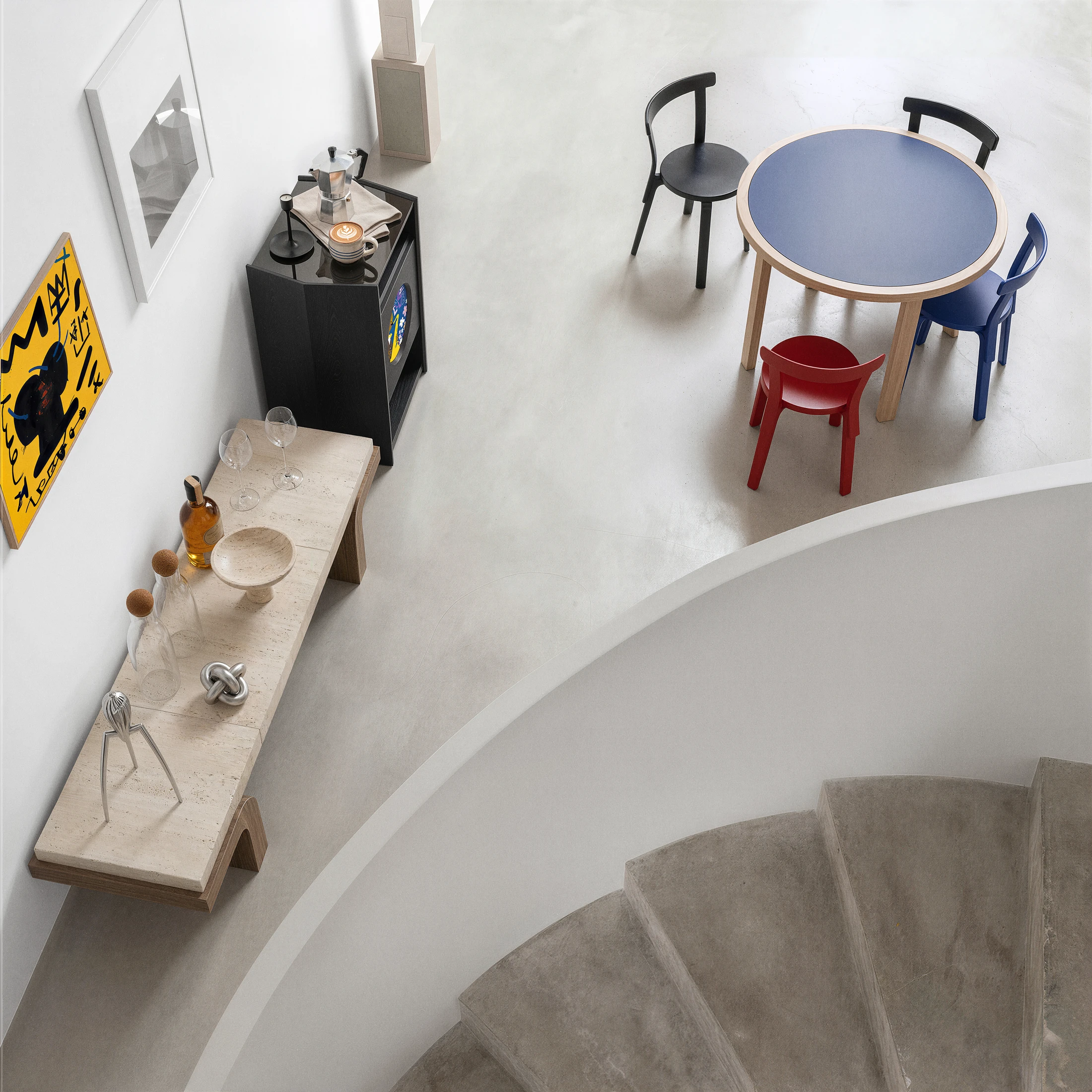 A Picasso stand next to a sculptural counter and colorful dining chairs